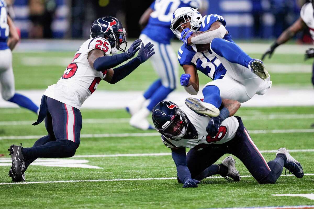 Indianapolis Colts running back Deon Jackson (35) is tripped up by Houston Texans safety Jonathan Owens (36) during the first half of an NFL football game Sunday, Jan. 8, 2023, in Indianapolis.