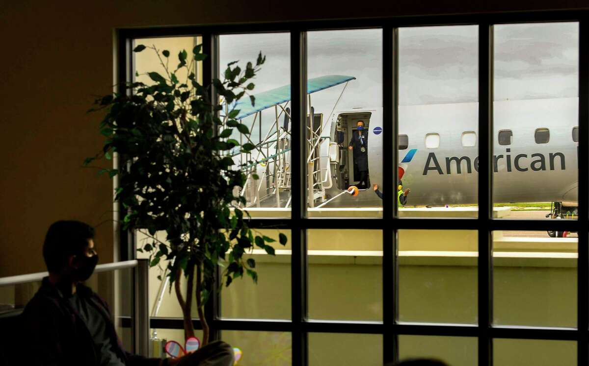 An American Eagle Embraer is parked on the tarmac awaiting passengers as seen through the windows at Del Rio International Airport in 2020. American Airlines is ending service at the airport in April, citing “soft demand” and a pilot shortage.