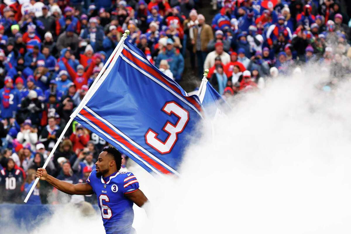 Buffalo receiver Isaiah McKenzie carries a flag bearing Damar Hamlin’s number before the game.