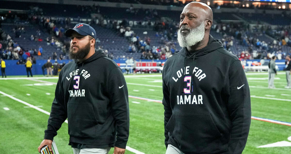 Houston Texans head coach Lovie Smith walks off the field with linebackers coach Miles Smith, left, after the Texans beat the Indianapolis Colts 32-31 in an NFL football game Sunday, Jan. 8, 2023, in Indianapolis.