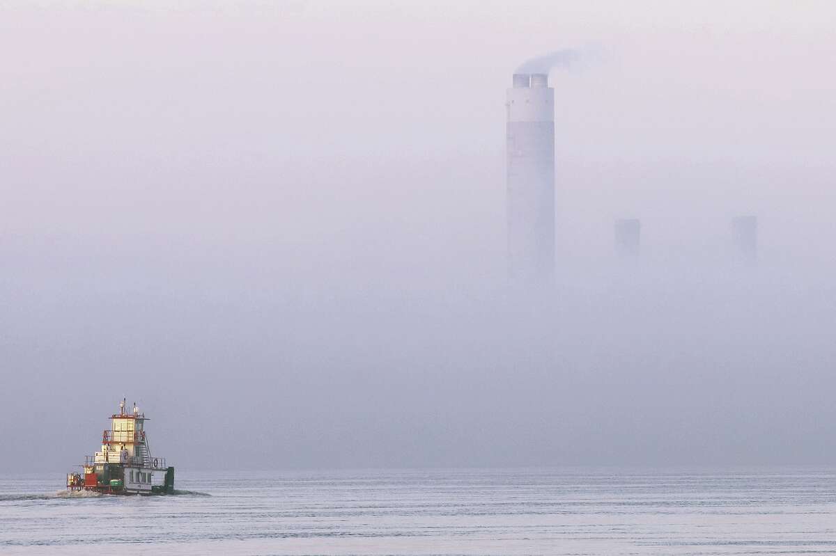 John Badman|The Telegraph A lone towboat heads upstream on Alton Lake Monday toward fog nearly obscuring the AmerenUE Sioux Power Plant in Portage Des Sioux, Missouri. The river has provided for a variety of different types of fog in recent weeks as the temperature of the water and the temperature of the air have clashed on and around the river.