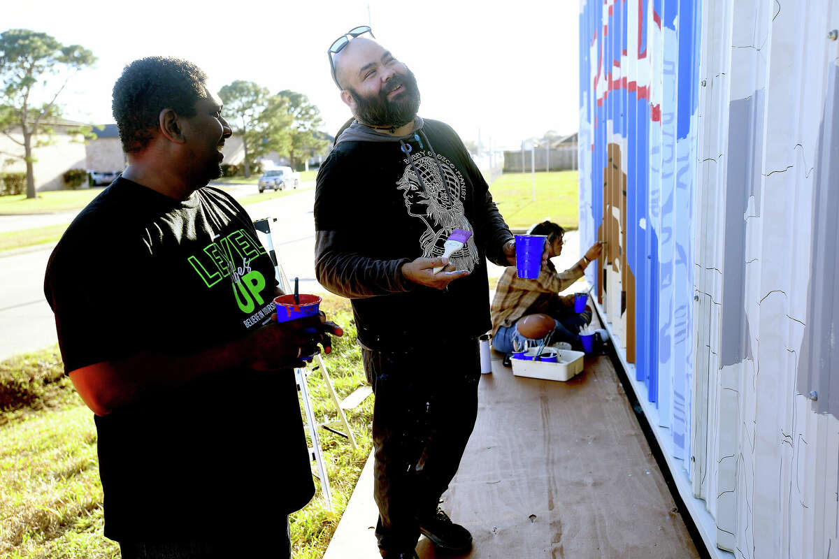 Instructor Maurice Abelman talks with student Cory Turner as they work on a series of murals on the exterior of the Port Arthur Little Theatre Friday. Students in Abelman's advanced graphic design class created the murals last semester and are painting them before the theater's new season begins later this month. Photo made Friday, January 6, 2023 Kim Brent/Beaumont Enterprise