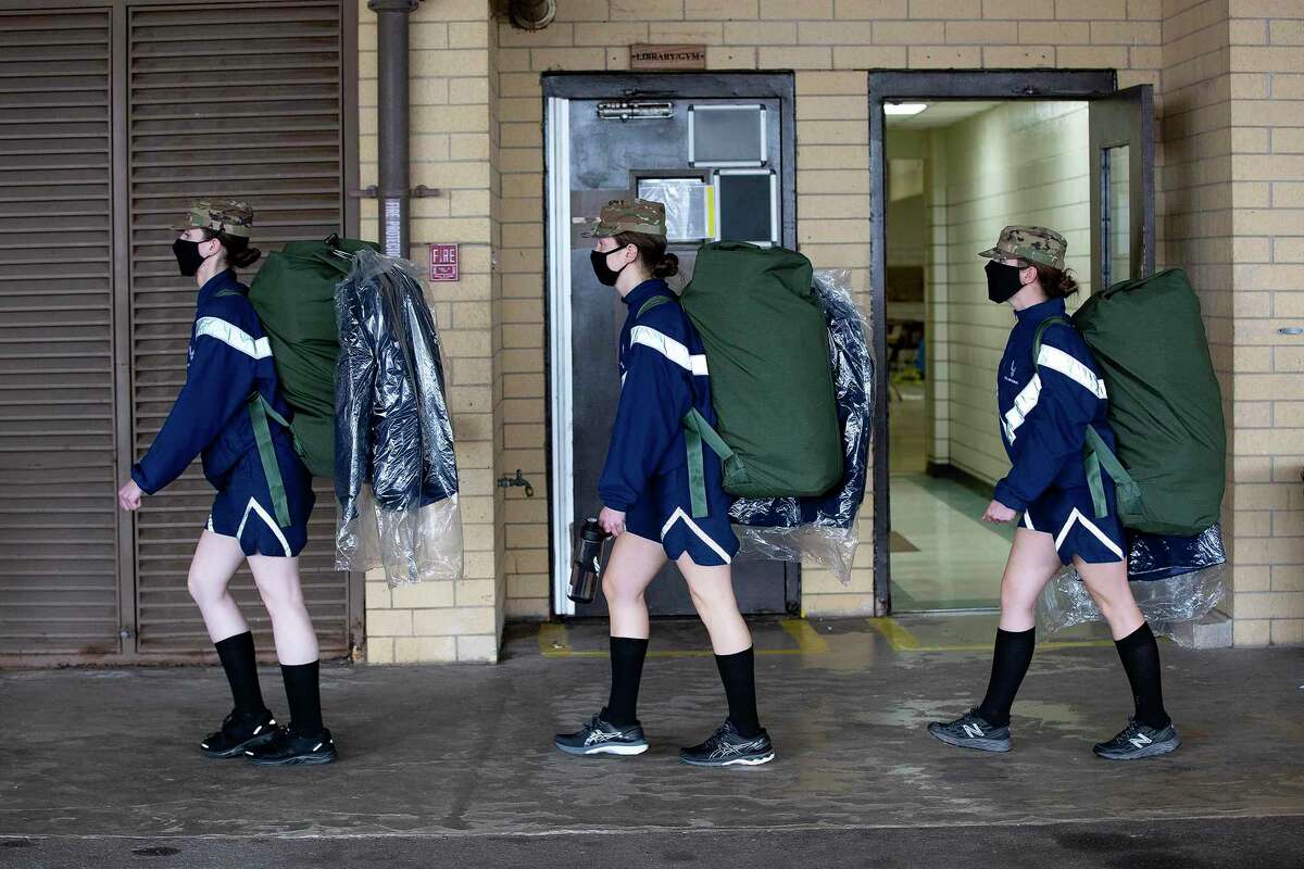 Trainees at Joint Base San Antonio-Lackland walk back to their dorms while carrying the dress blues they were issued on Feb. 25, 2021.