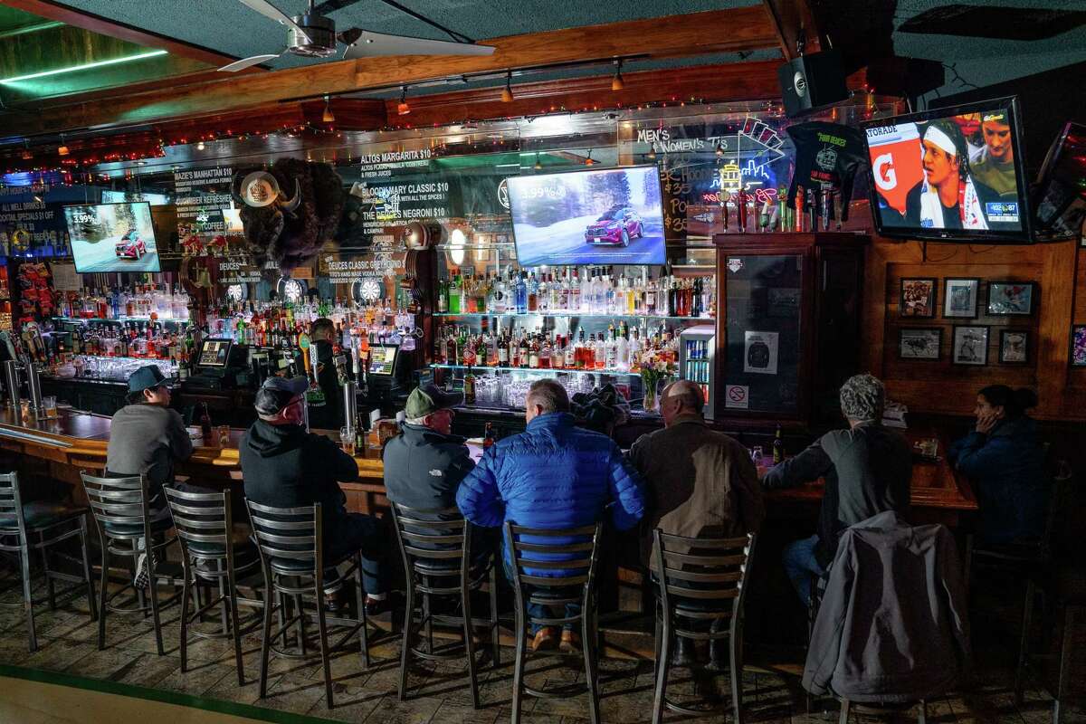 旧金山的酒吧顾客在Four Deuces观看足球比赛。企业正试图恢复正常，但高传染性的欧米克隆变种冠状病毒仍在跟踪这个国家。