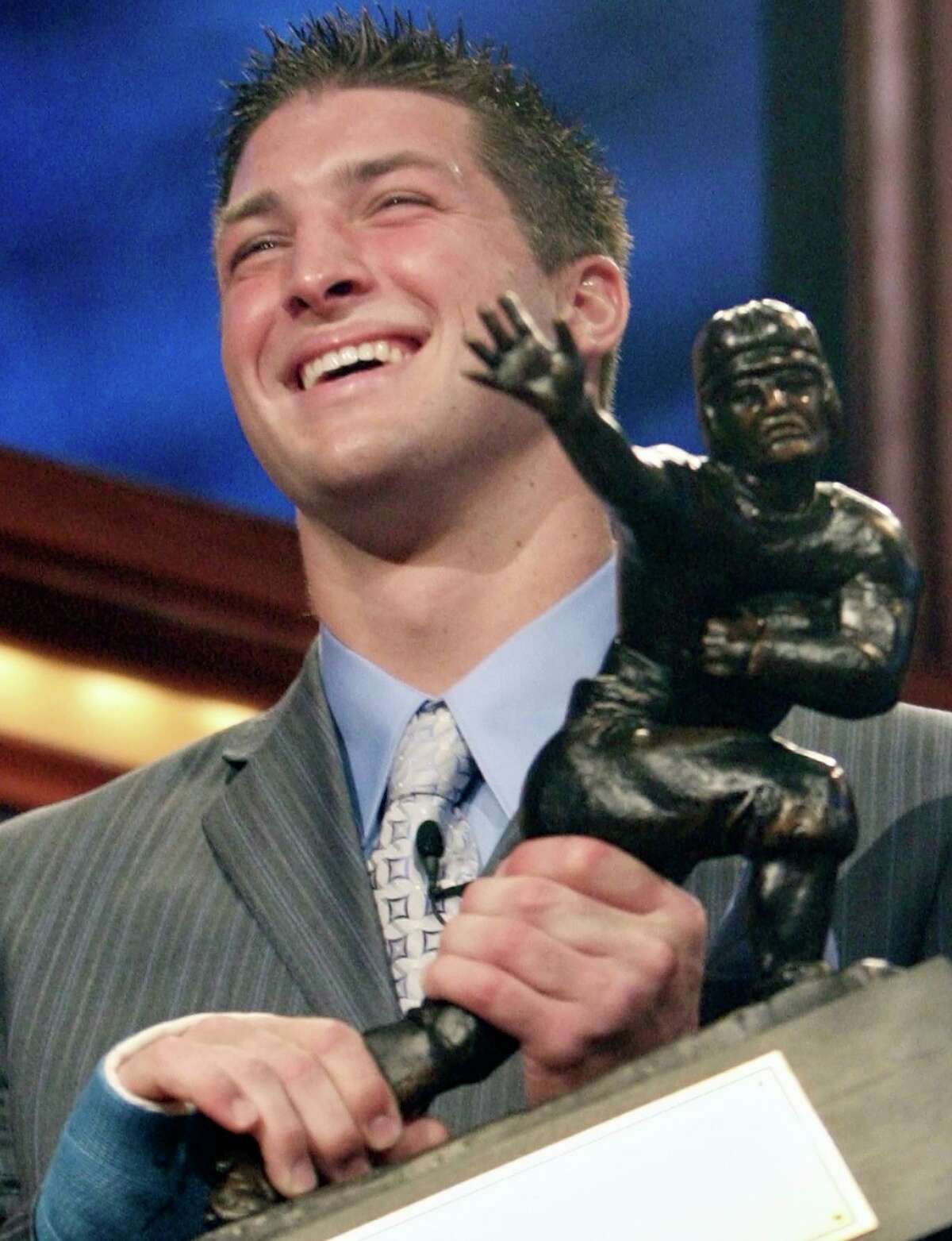 FILE - Florida quarterback Tim Tebow holds up the Heisman Trophy after winning the award Saturday, Dec. 8, 2007 in New York. Tebow was elected to the College Football Hall of Fame, Monday, Jan. 9, 2023. (AP Photo/Kelly Kline, Pool, File)