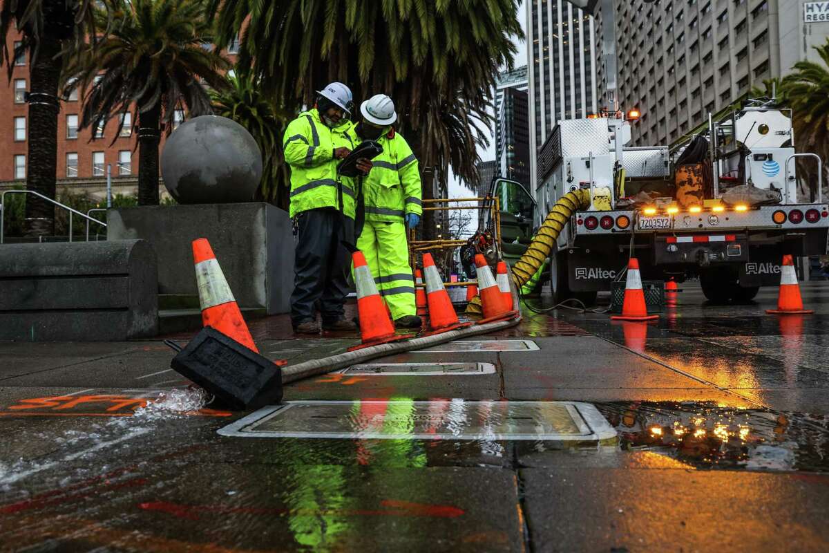 AT&T workers pump water out of a utility vault near San Francisco’s Embarcadero during the Jan. 4 storm.
