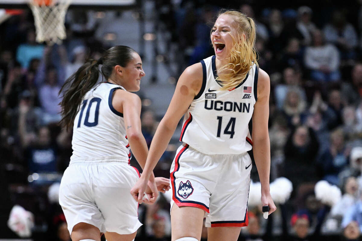 Connecticut's Nika Muhl (10) celebrates with Connecticut's Dorka Juhasz (14) after Juhasz hit a 3-point basket during the first half of an NCAA college basketball game against Florida State, Sunday, Dec. 18, 2022, in Uncasville, Conn. (AP Photo/Jessica Hill)