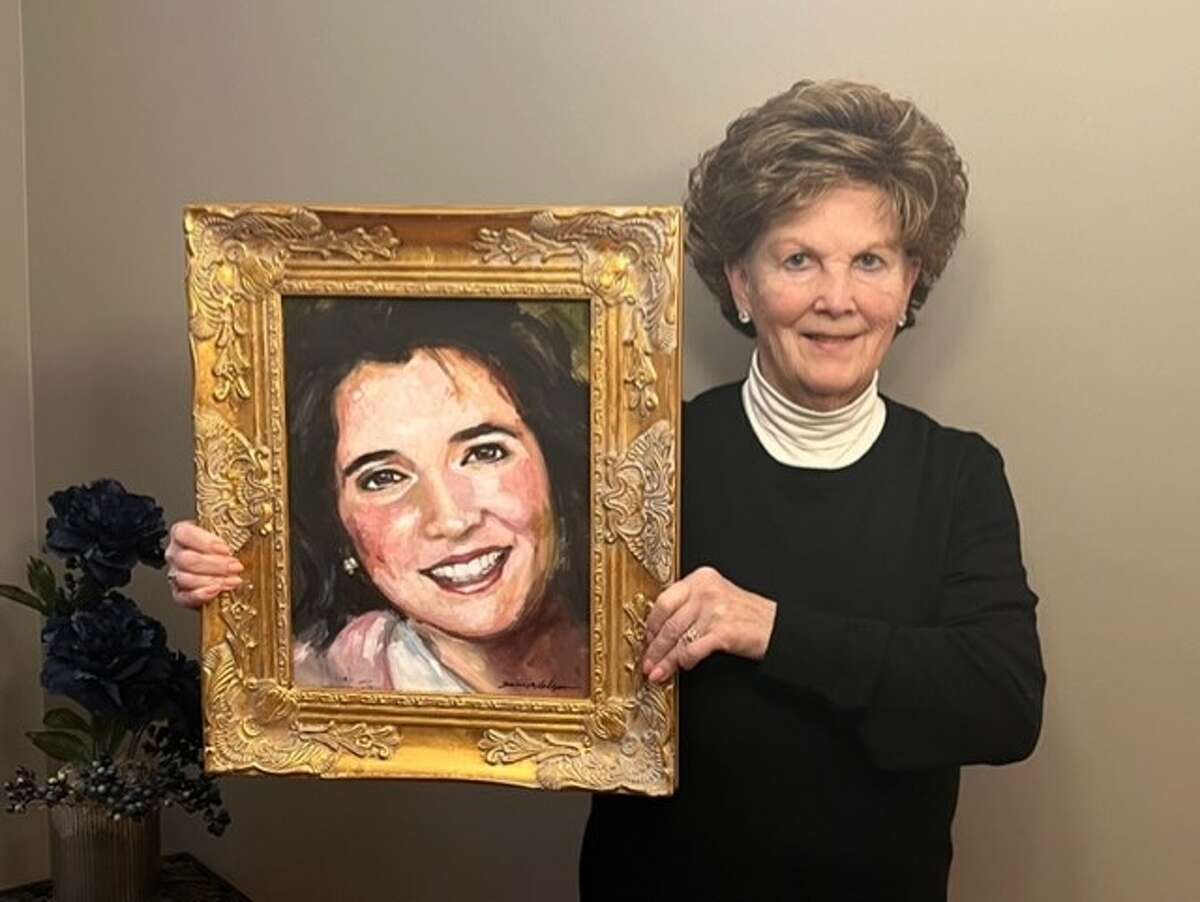 Mardie Pohanka, award recipient, holds a portrait of the late Stephanie Stephan. The painting was created by local artist Susie McColgan. 