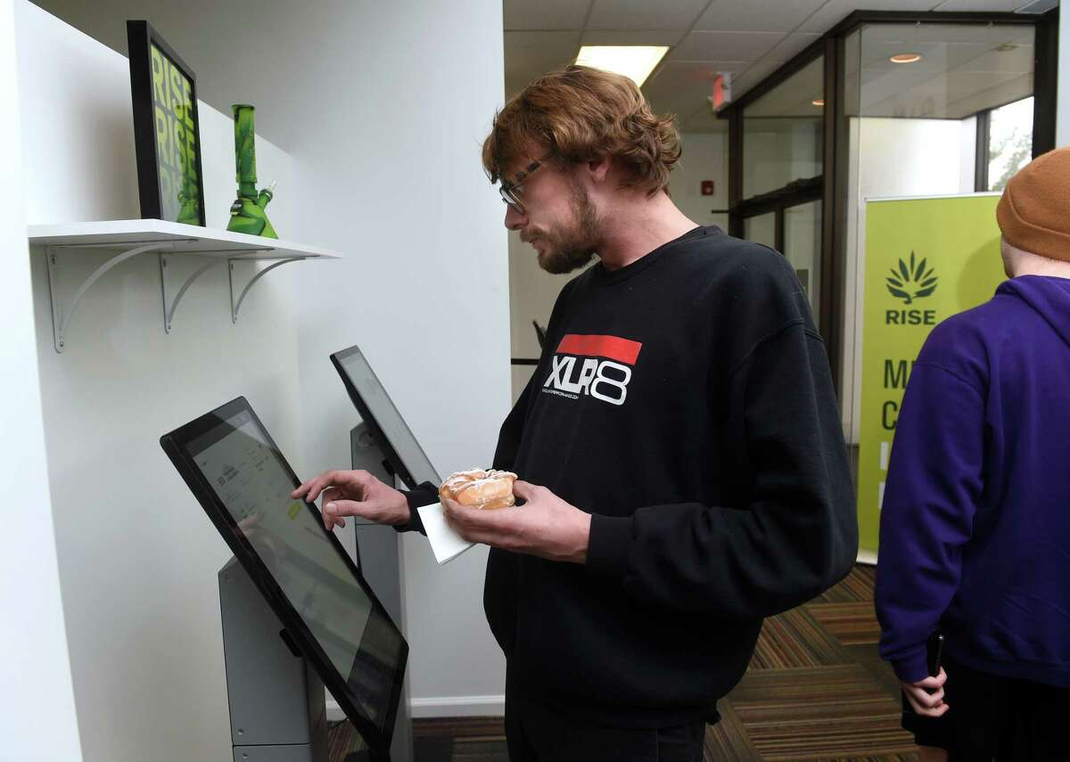 Craig Miller of Branford places an order at a kiosk inside Rise in Branford on the first day of recreational cannabis sales Tuesday.