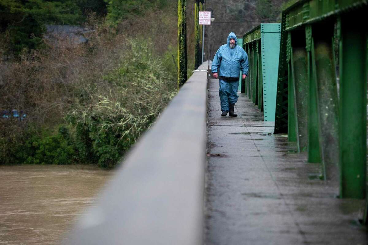 Jack Raschke of Monte Rio walks across the Monte Rio Bridge to look at the Russian River flooding on Tuesday.