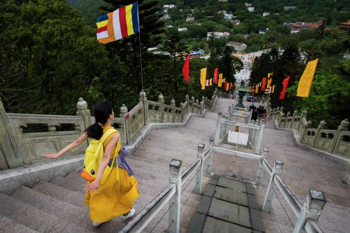 Taking the stairs is a great way to get your exercise in. A woman glides down the stairs leading to the Tian Tan Buddha statue in Hong Kong, China.
