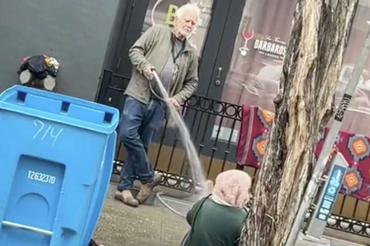 Collier Gwin sprays a homeless woman with a hose in an image capured on video. San Francisco police said they are investigating the incident.