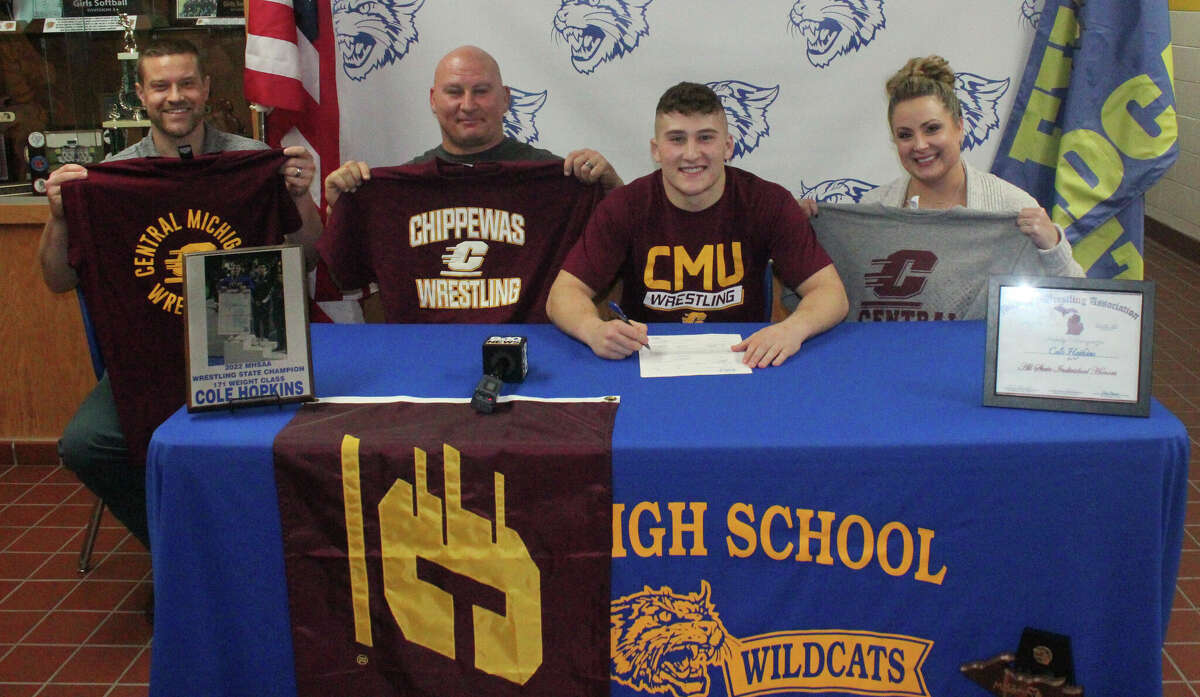 Evart senior Cole Hopkins (second from right) signs his national letter of intent on Tuesday to be a wrestler at Central Michigan University. Pictured, from left, are Evart head wrestling coach Ben Bryant, assistant coach and Cole's father Ryan Hopkins; Cole Hopkins; and his mother Valerie Hopkins.