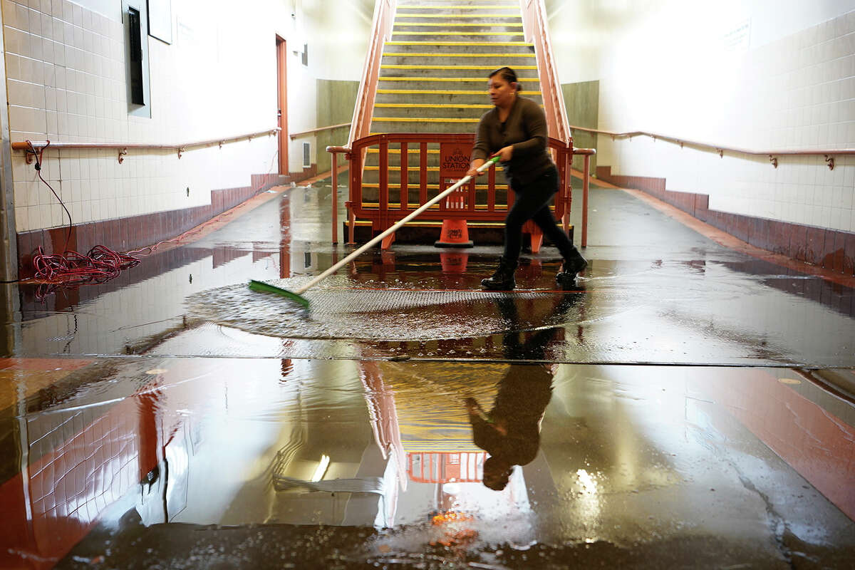 Crews work to drain rainwater flooding the Union Station's pedestrian passageway, which leads to train platforms in Los Angeles, Tuesday, Jan. 10, 2023.