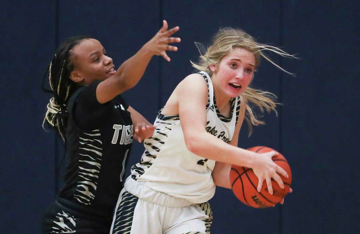 Lake Creek's Romy Gross (2) looks to pass under pressure by A&M Consolidated's Kateria Gooden (11) during a District 21-5A high school basketball game at Lake Creek High School, Tuesday, Jan. 10, 2023, in Montgomery.