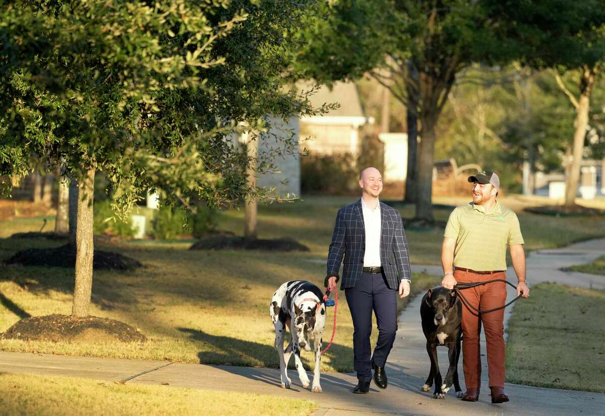Aaron Dailey, left, and Johnny Dailey, right, walk their dogs Penelope, left, and Charlie, right, in their master-planned community Tuesday, Jan. 10, 2023, in Spring.