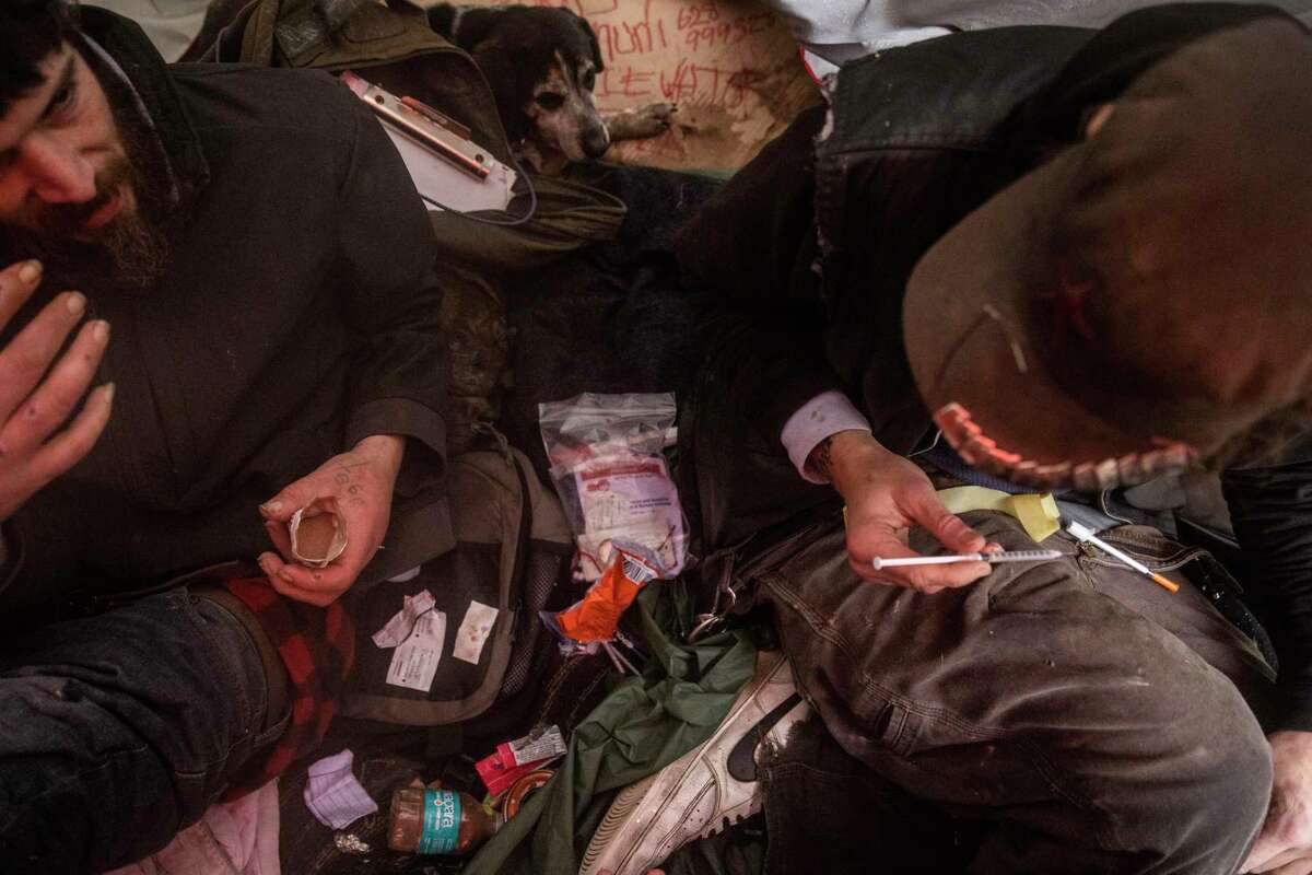 Andy Berger, left, gestures as friend Spencer Gray prepares a fentanyl injection inside a tent in San Francisco, California Tuesday, Jan. 10, 2023.