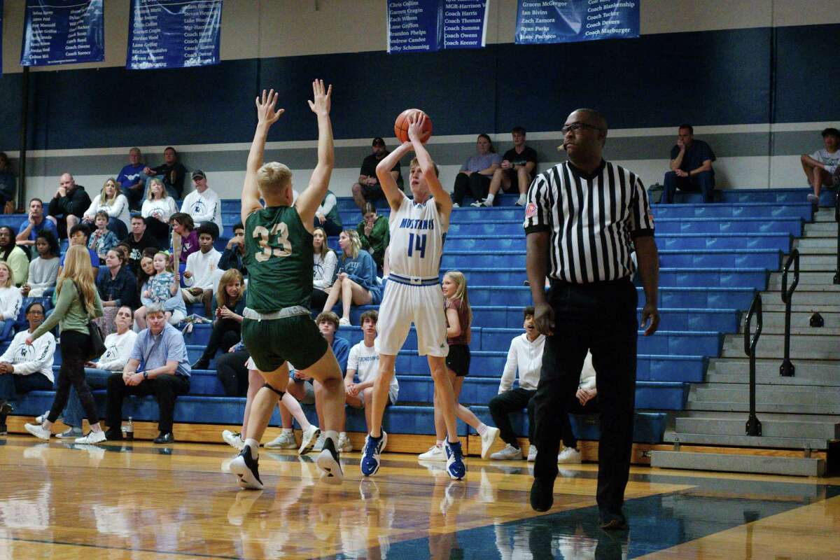 Friendswood’s Jackson Fiesinger (14) puts up a shot over Santa Fe’s Ty Clark (33) Tuesday, Jan. 10, 2023 at Friendswood High School.