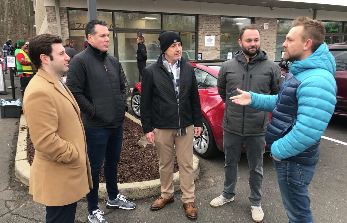   State Rep. Josh Elliott, right, talks with executives and managers of Verano, the company that owns the Zen Leaf cannabis store in Meriden, at the store's opening for adult-use on Tuesday. At center is Rino Ferrarese, head of Verano's northern operations. 