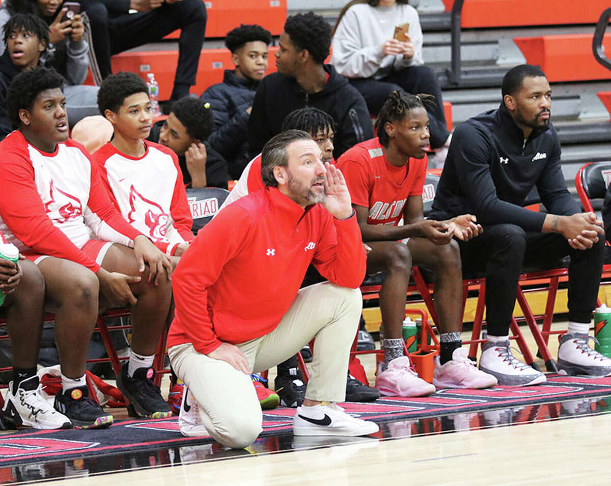 Alton coach Dylan Dudley coaches his Redbirds on defense against in front of the team bench in the first half against Triad in Saturday's game at Rich Mason Gym in Troy.