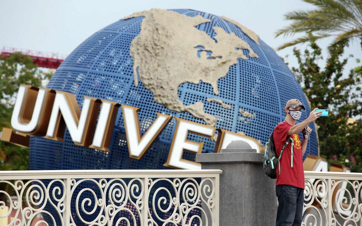 A visitor takes a selfie at Universal Studios theme park on the first day of reopening from the coronavirus pandemic, on June 5, 2020, in Orlando, Florida.