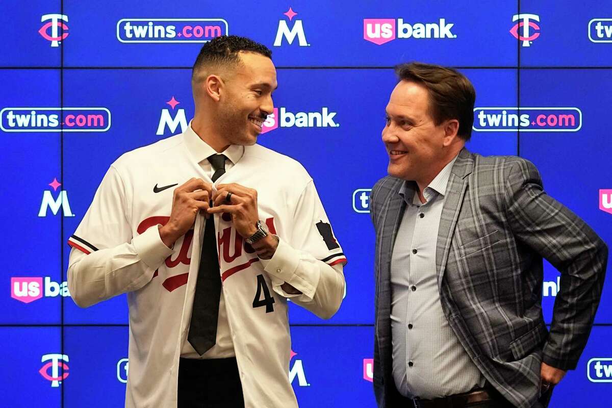 Minnesota Twins' Carlos Correa, left, puts on a team jersey alongside Twins president of baseball operations Derek Falvey at Target Field Wednesday, Jan. 11, 2023, in Minneapolis. The team and Correa agreed to a six-year, $200 million contract.
