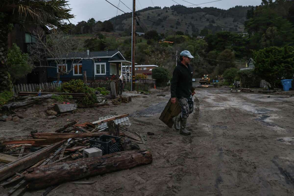 Dino Colombo salvages debris on Jan. 6 after the exterior of his Stinson Beach home was damaged by rain and wind.
