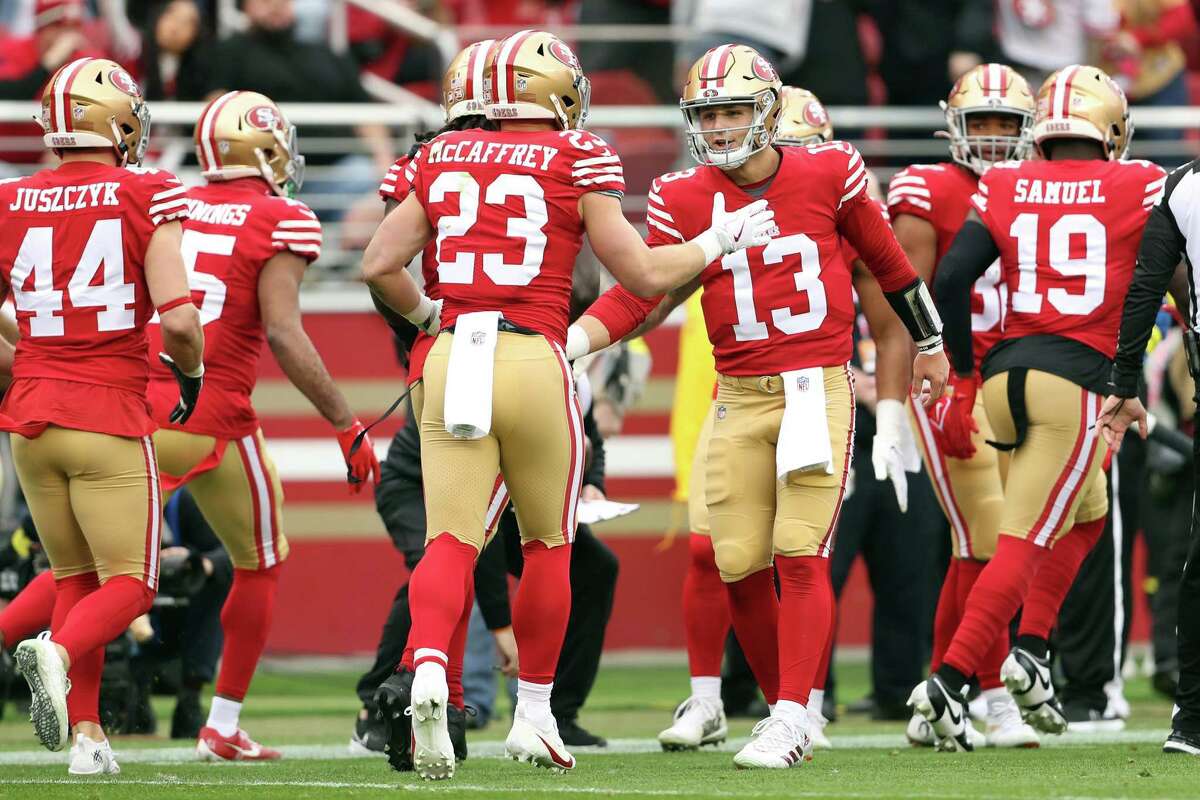 San Francisco 49ers’ Brock Purdy slaps hands with Christian McCaffrey after McCaffrey scored on a 21-yard pass reception against Arizona Cardinals in 1st quarter during NFL game at Levi’s Stadium in Santa Clara, Calif., on Sunday, January 8, 2023.