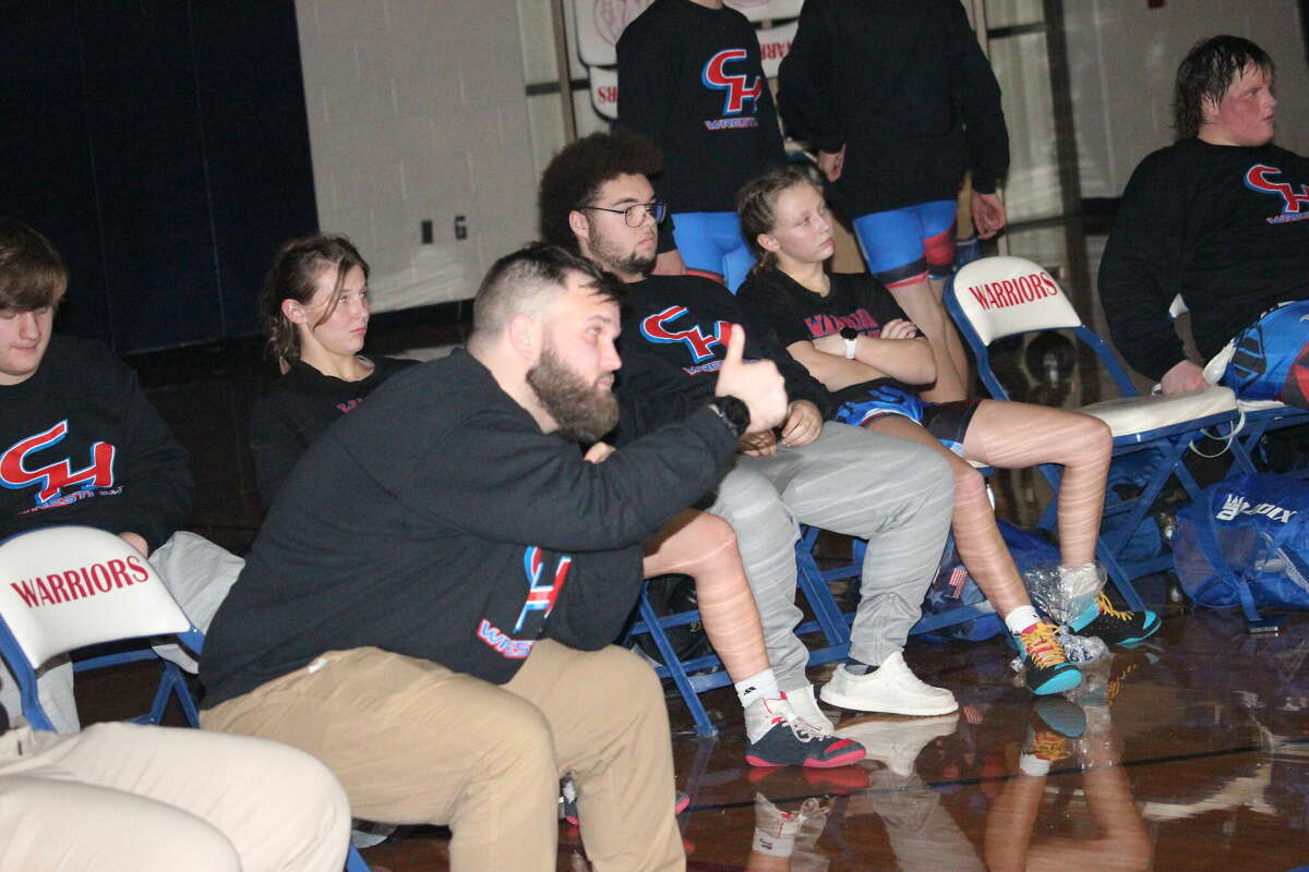 Chippewa Hills wrestling coach Tyler Vogel signals to his wrestler to take the up position at a recent match. The Warriors defeated Reed City and Newaygo on Wednesday.