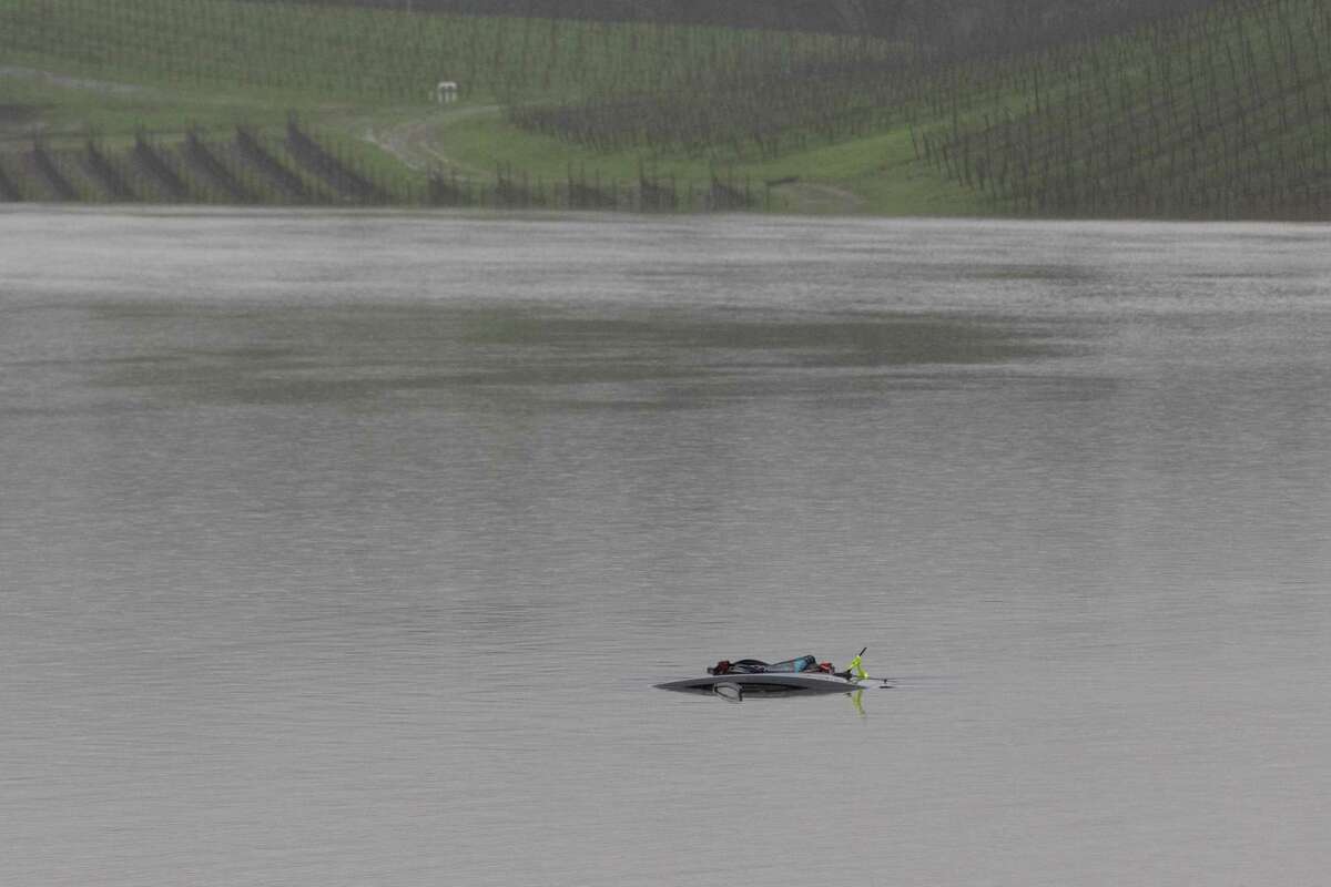 The top of a car is marked with flotation devices in the flooded area of a vineyard along the 6000 block of Trenton-Healdsburg Road in Forestville on Wednesday. Sonoma Sheriff’s Twitter account announced they had recovered the body of a 43-year-old individual from a submerged car in the area.