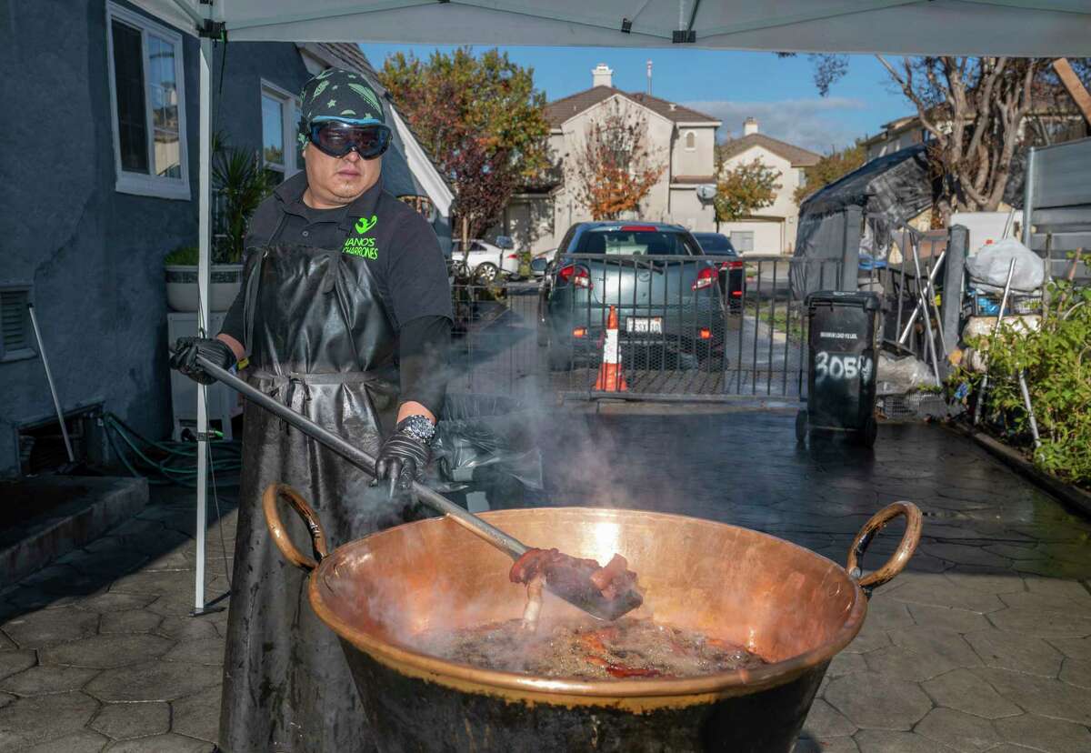 Nano's Chicharrones co-owner Juan Ballona looks like a mad scientist tending to crackly chicharrones on the driveway of his home in San Jose.