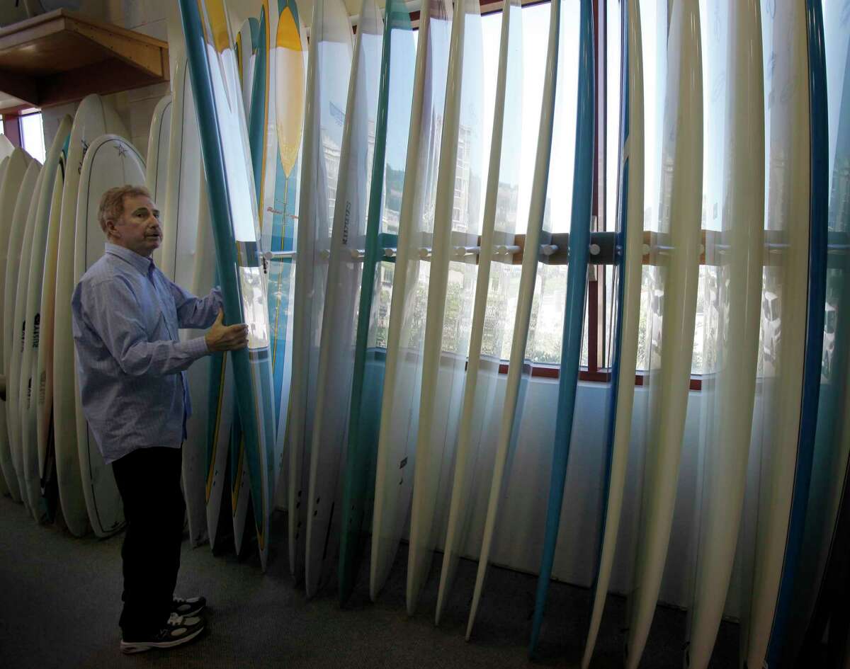 Bob Wise looks at some longboards at his store.