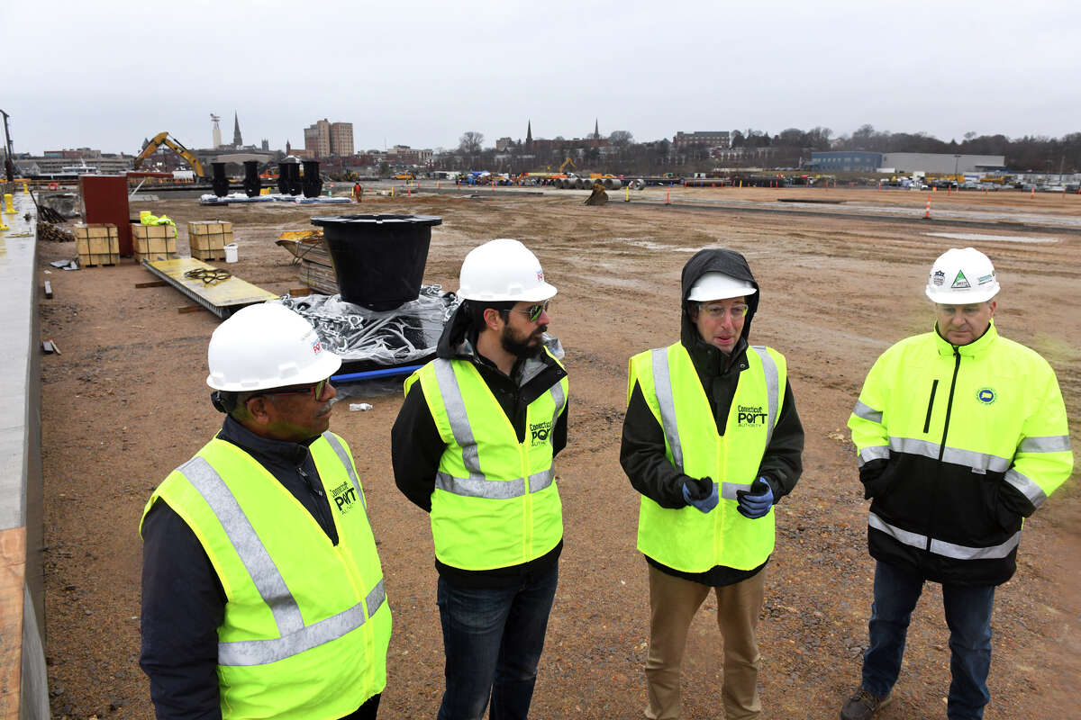 David Kooris, third from left, Board Chairman of the Connecticut Port Authority, speaks during a tour of the New London State Pier upgrade project currently underway in New London, Conn. Jan. 12, 2023. When complete, the pier facility will serve as a heavy-lift cargo port for a variety of modern uses, including as a hub for the burgeoning offshore wind industry. Kooris is seen here with port authority Executive Director Ulysses Hammond, Business Projects and Special Projects Manager Andrew Lavigne and Program Manager Joseph Salvatore.