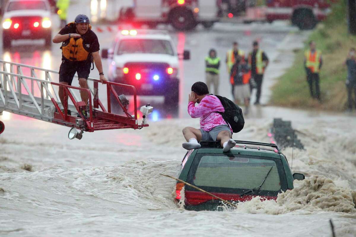 San Antonio Fire Department personnel rescue a man trapped on top of his submerged vehicle at a low water crossing on Pinn Road by SH151, Monday, August 7, 2017.