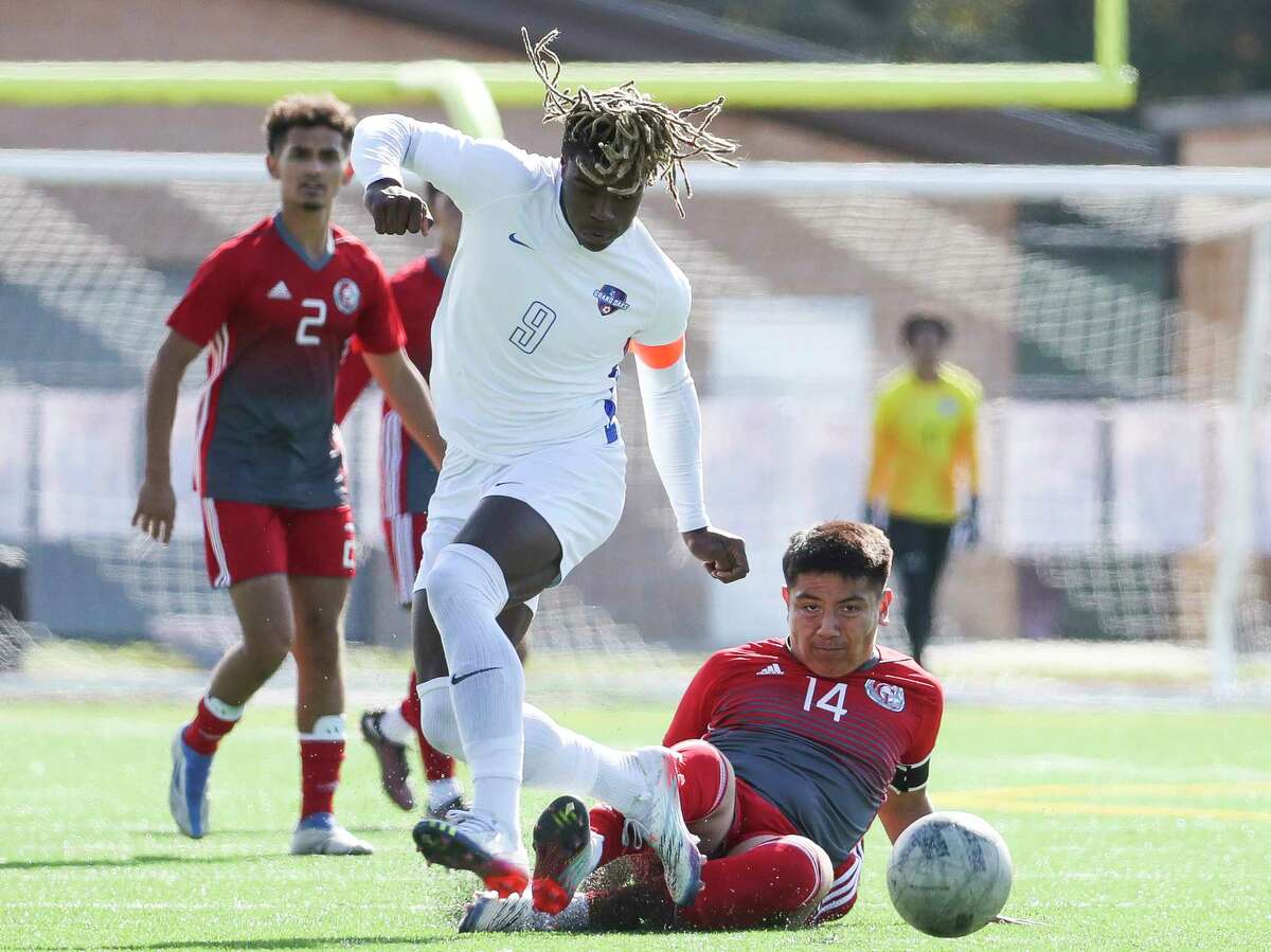 Grand Oaks’ Ramiere Johnson (9) goes after the ball in front of Cypress Lakes’ Josue Andrade (14) in a high school soccer match during the Humble ISD Classic at Kingwood Park High School, Thursday, Jan. 11, 2023, in Kingwood.