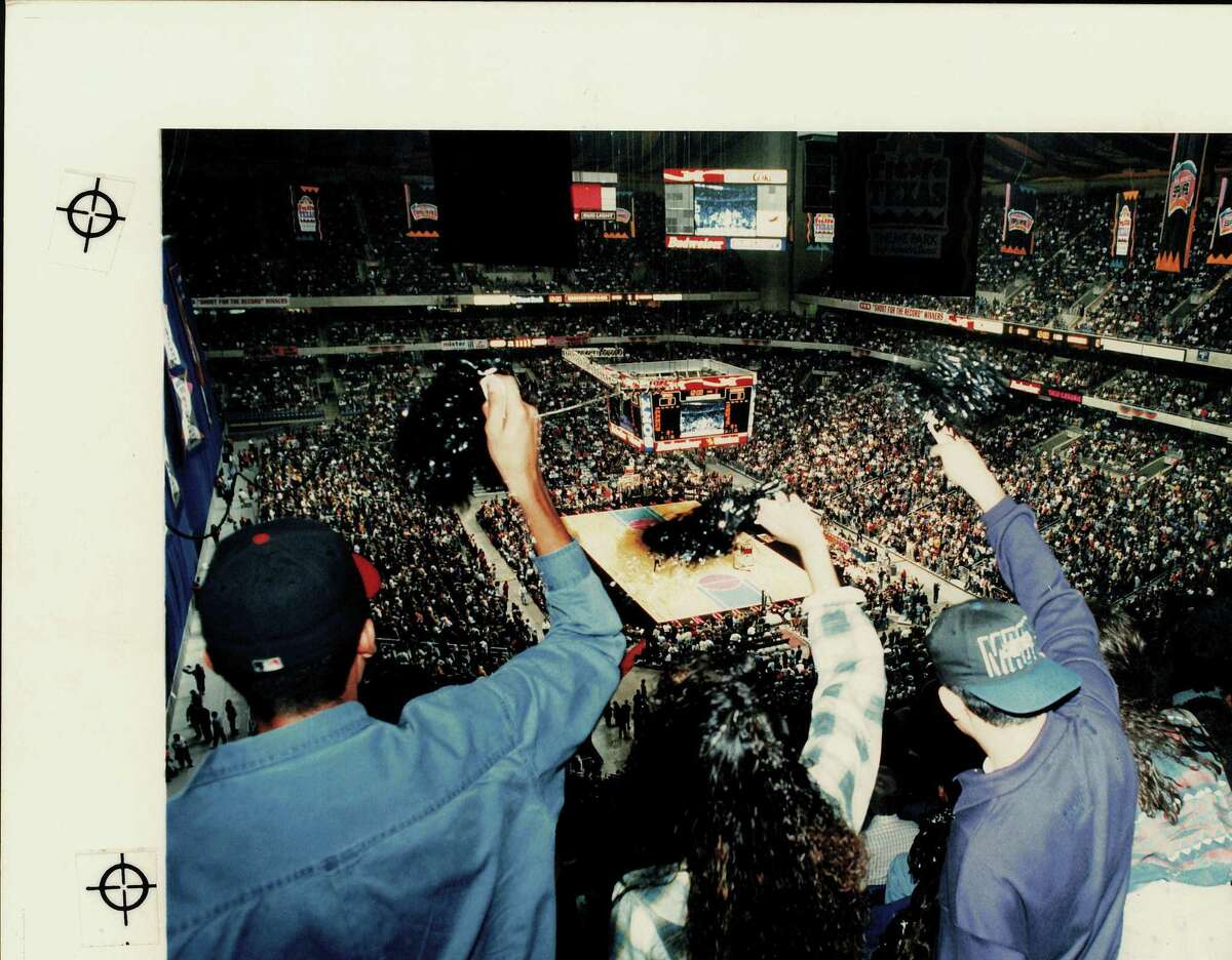 Fans whoop it up with silver and black pom poms as the San Antonio Spurs take the court for the Spurs opening game of the 1993-94 season. The attendance set new NBA record; Alamodome NBA basketball