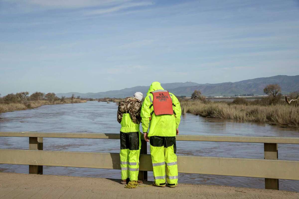 A crew from the Geological Survey monitors water levels of the Salinas River. Over the next few days, Monterey County officials warn that the potential for flooding along the