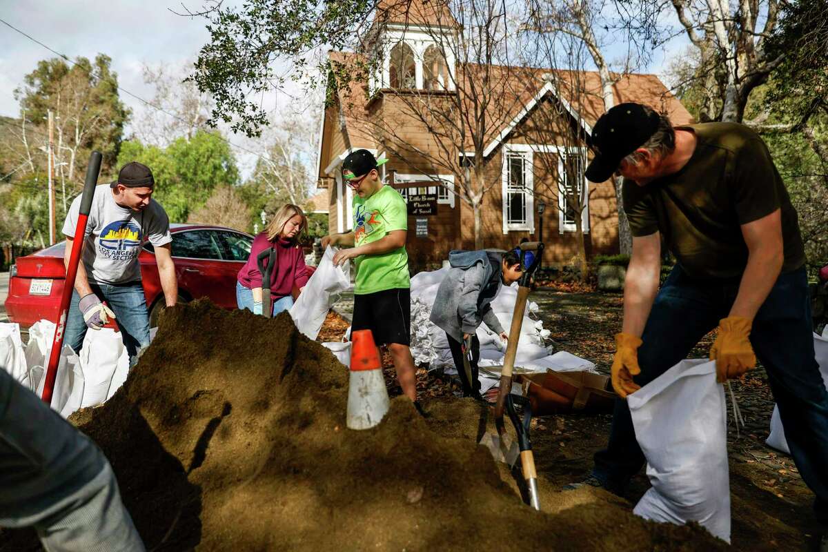 Sunol residents fill sandbags for those not able to fill their own outside the town’s Little Brown Church.