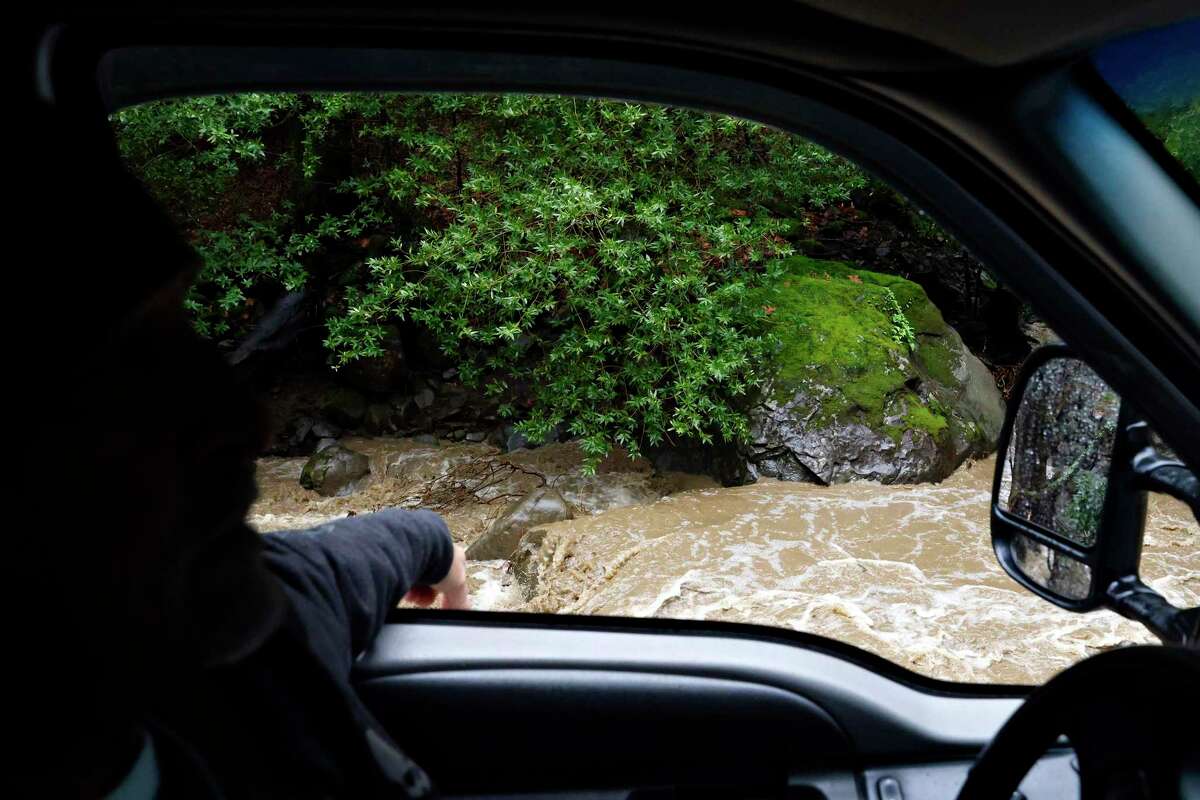 Jeff Ysit drives up Kilkare Road along the rushing Sinbad Creek in Sunol, Calif. Thursday, Jan. 5, 2023 after heavy rains caused mudslides, flooding and other hazardous conditions across the already devastated town.