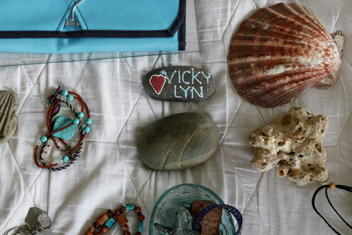 Shells, rocks and other jewelry my mom had on her dresser sits on her bed while my stepdad clears out their flooded room.