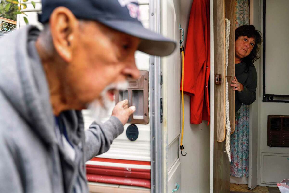 Jessica Christian’s grandfather, Ario Ysit, checks on the photographer’s mother at the renovated camper trailer she moved into while her flooded home is assessed.