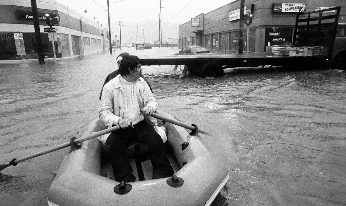 Jan. 5, 1982: Two men use an inflatable raft and oars to navigate the streets of San Rafael, which were covered in floodwaters after a 1982 storm.
