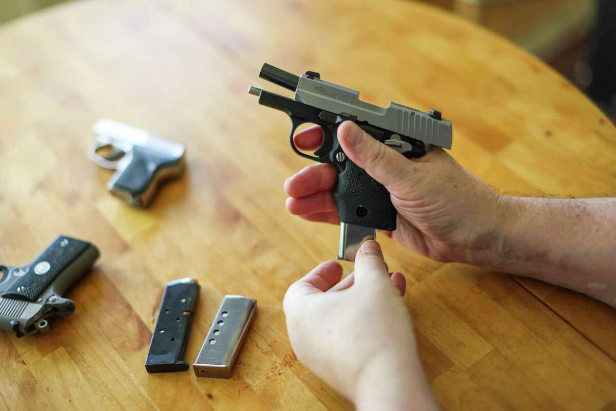 Private investigator Andrew Solow reloads guns as he puts them away at his home in San Francisco on Friday, Nov. 25, 2022. Solow is applying for a permit to carry a concealed weapon.