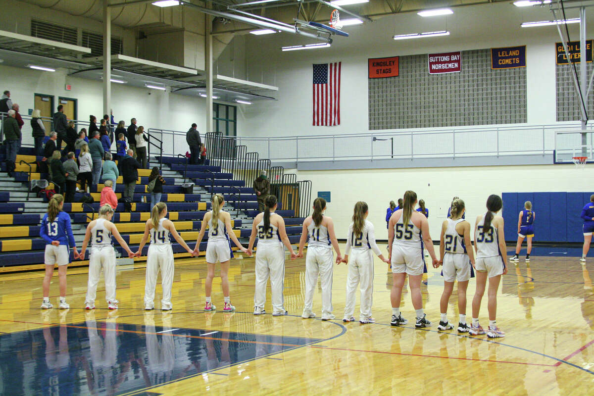 The Onekama girls team gathers for the playing of the national anthem before a game against Buckley on Jan. 12 at Onekama Consolidated Schools. 