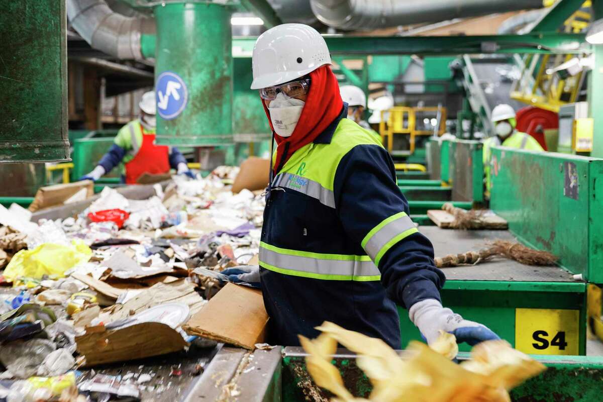 Recology employees sort line sort through recycled materials at Pier 96 in San Francisco.