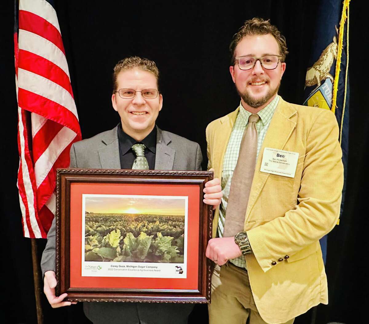 Michigan Sugar Company Director of Research and Agronomy Corey Guza, left, receives a conservation award from Ben Wickerham on behalf of Michigan Sugar.