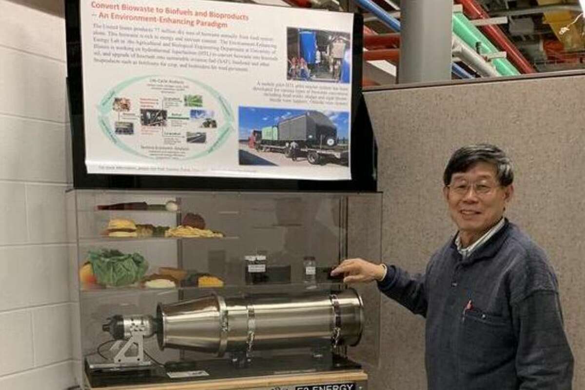 Yuanhui Zhang, University of Illinois, shows a poster and model of a USDA-funded project aiming to convert biowaste into fuels and pavement binder.
