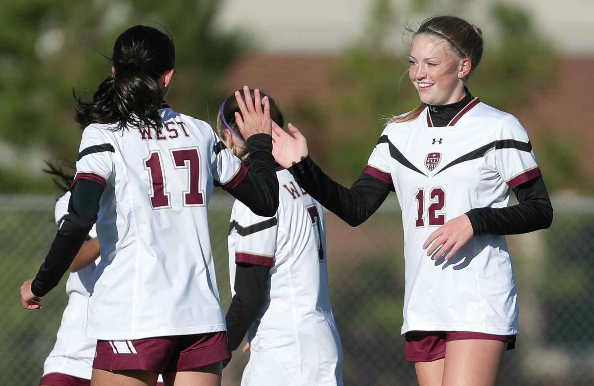 Magnolia West's Amie Sumrall (12) gets a high-five from Avery Riley (17) after scoring a goal during a high school soccer match at the Kat Cup soccer tournament at Willis High School, Friday, Jan. 13, 2023, in Willis.