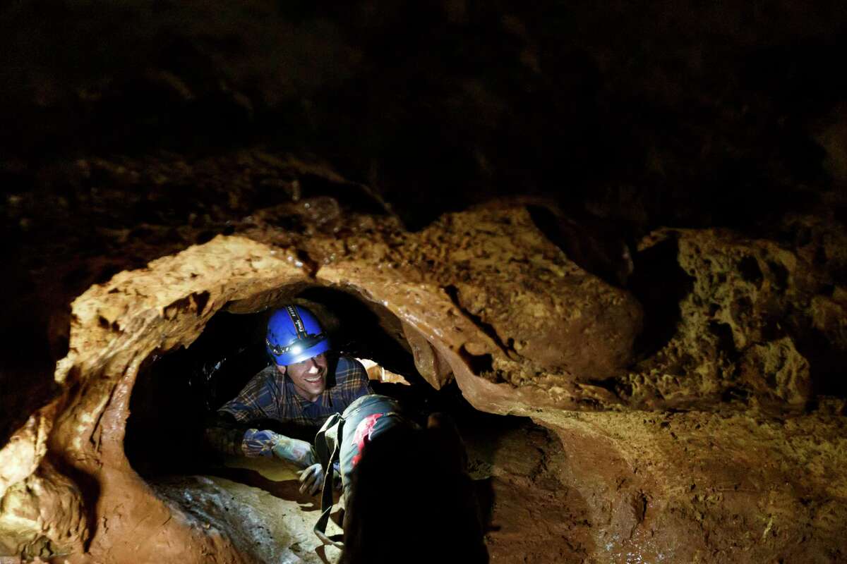 John Moretti, a paleontologist and doctoral student at the University of Texas at Austin’s Jackson School of Geosciences, crawls through a 40-foot stretch of tunnel called the Birthing Canal during a research trip inside Natural Bridge Caverns in San Antonio, Texas, Tuesday morning, Jan. 10, 2023.