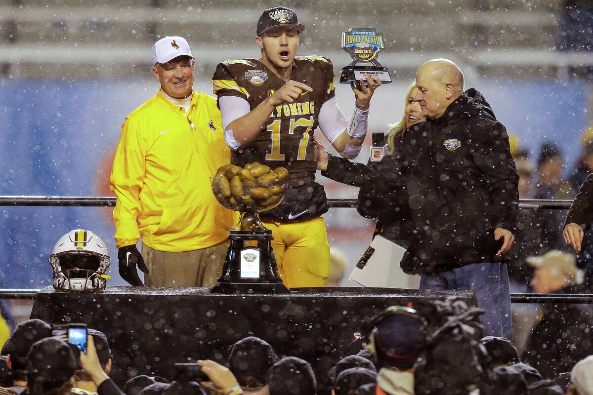 Josh Allen accepting the MVP award from Idaho Potato Commission CEO Frank Muir alongside Wyoming Cowboys head coach Craig Bohl after the Famous Idaho Potato Bowl on Dec. 22, 2017, at Albertsons Stadium in Boise, Idaho.